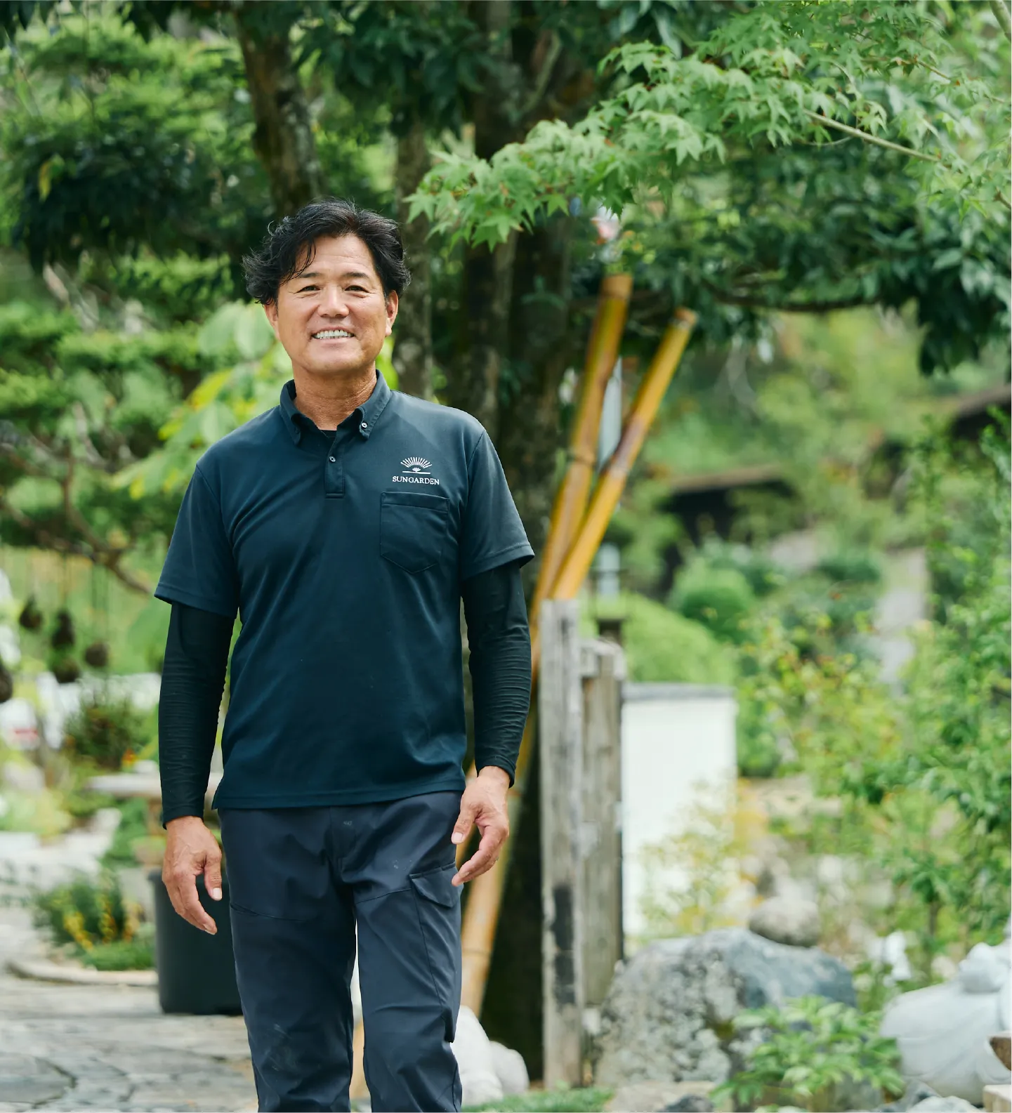 庭にて笑顔で立つ男性