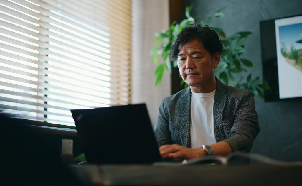 オフィス内で男性がパソコンを使って作業をする様子
